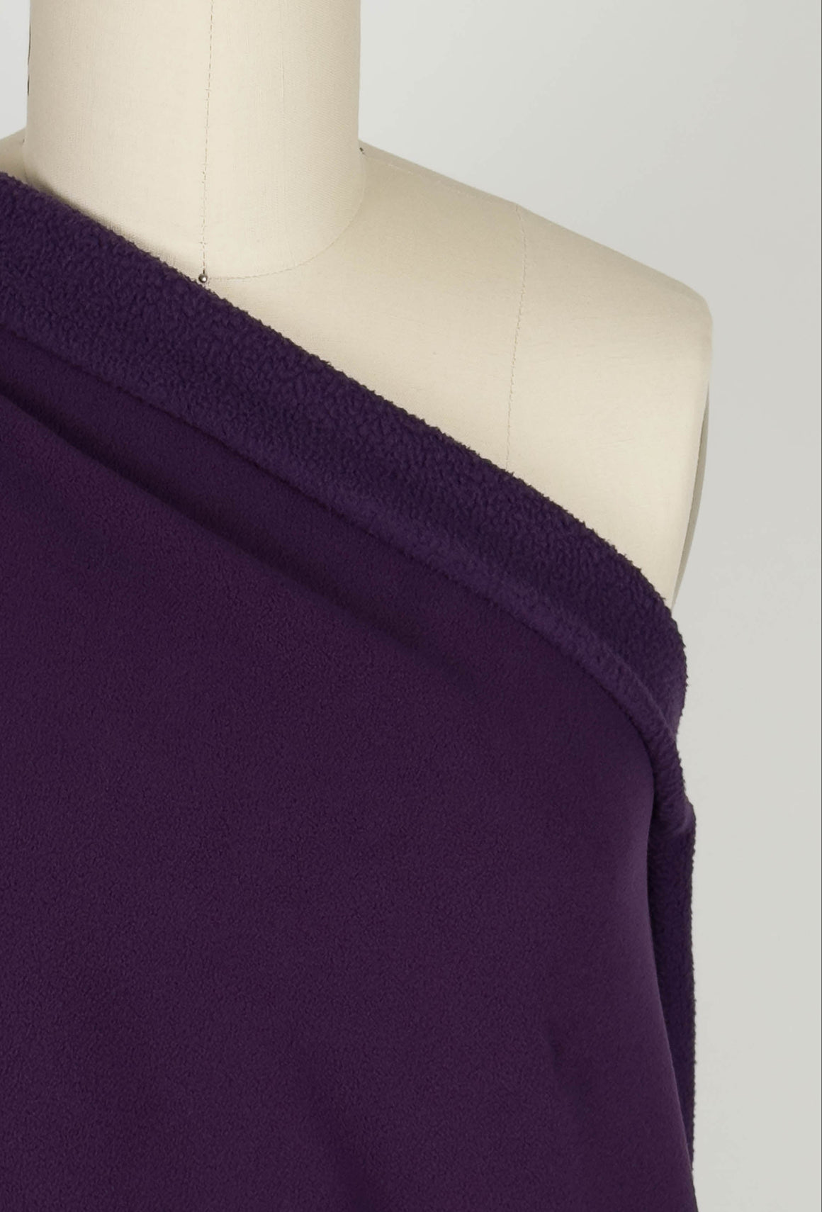 Purple sherpa fleece fabric draped over a mannequin.