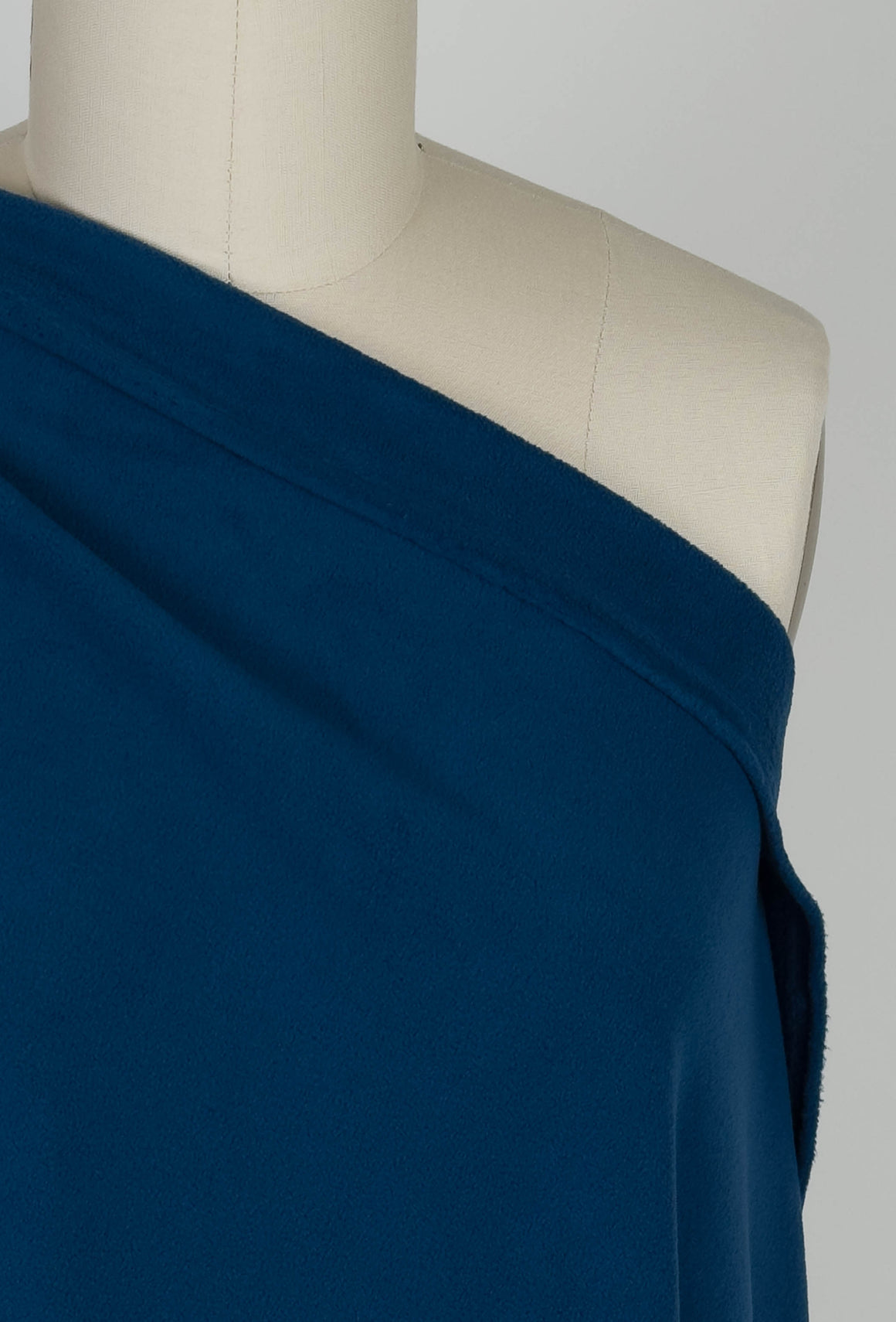 Navy blue velour fleece fabric draped over a mannequin 